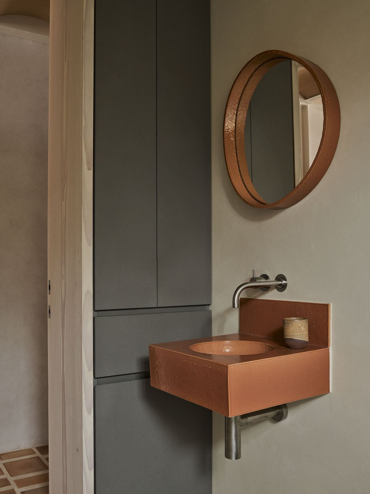 Clay House powder room. Copper basin against soft grey joinery.